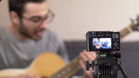 Recording a Guitar Playing Tutorial on Camera 動画素材 106627567