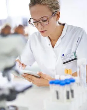 Recording her data for further analysis. A young scientist working on a research Stock Photos
