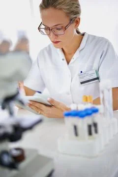 Recording her data for further analysis. A young scientist working on a research Foto stock