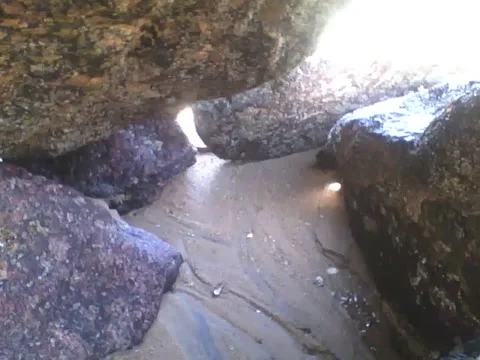 Recording inside of the rocks on the beach, it's very narrow and tight Stock Footage 163683317