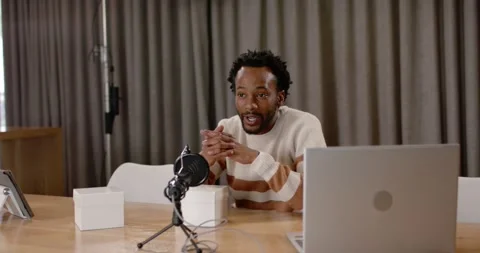 Recording man wearing jumper at studio speaking to mic checking laptop pointing Stock Footage 345590231