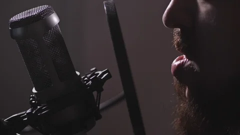 Recording studio. Close-up. A man with a beard sings a song or reads the text Stock-Footage 105287240