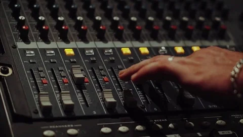 Recording studios audio console and a hand pulling up the knobs Stock Footage 69838382