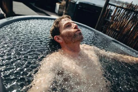 The recovery ritual features a man practicing breathwork in an outdoor ice .. Stock Photos