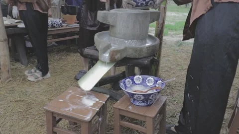 Recreating the Scene of Rice Flour Rotation on a Stone Mill, a traditional VN Stock Footage 260363613