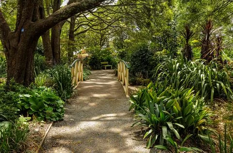 A recreation park with sculptures, flowers, paths and bridges. Stock Photos