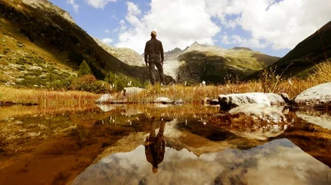 Recreational activity of young man in mountain lake landscape. arms raised Stock Footage 64799900