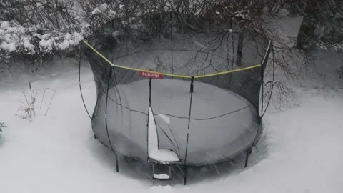 Recreational trampoline being bashed by a strong wind in a blizzard snow storm Stock-Footage 225555206