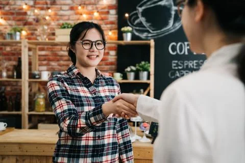 Recruiter at table shaking hands with applicant 스톡 사진