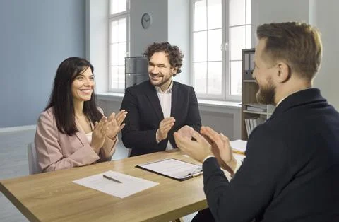 Recruiters applaud candidate for interview approval and hiring decision in Stock Photos