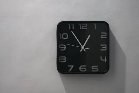 Rectangle analog wall clock with a black frame, white face, and bold black .. Stock Photos