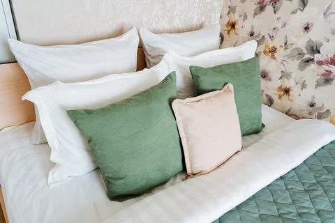 Rectangle bed with white linens, green and white pillow fashion accessories Foto stock