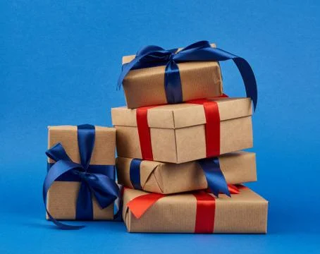 Rectangle box wrapped in brown kraft paper and tied with a silk blue and red  Stock Photos