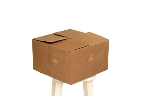 Rectangle cardboard box on beige stool for creative arts and toy storage Stock Photos