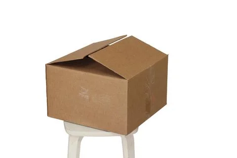 Rectangle cardboard box on beige stool for creative arts and toy storage Foto stock
