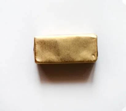 Rectangle chocolate candy wrapped in golden foil isolated on white surface Stock Photos