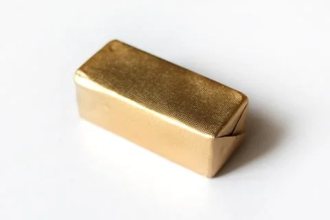 Rectangle chocolate candy wrapped in golden foil isolated on white surface Stock Photos