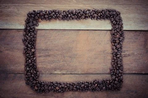 Rectangle frame made of coffee beans on the wooden background 스톡 사진
