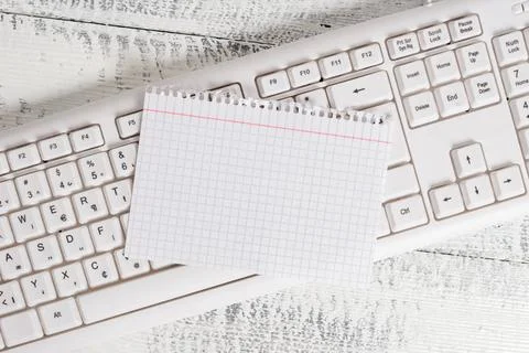 Rectangle shaped note colored paper in a keyboard and a white wooden backg... Stock Photos
