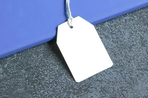 Rectangle white gift tag mockup with white cord, close up on black background Stock Photos