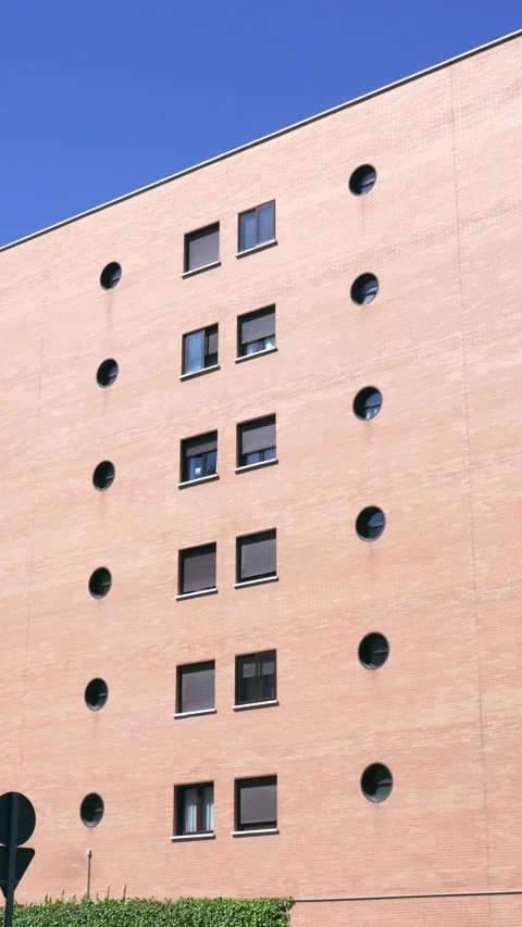 Rectangular and circular windows patterned on beige facade Stock Footage 336582429