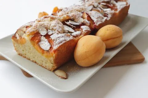 Rectangular appetizing homemade apricot pie on a rectangular plate, on a wood 스톡 사진