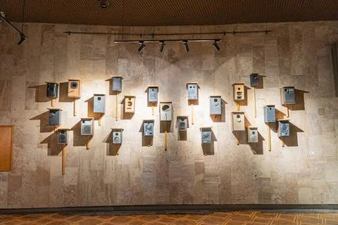 A rectangular arrangement of small boxes with slanted tops on a stone wall,.. 스톡 사진
