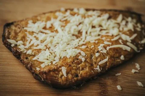 A rectangular baked dish, covered in melted golden cheese. Stock Photos