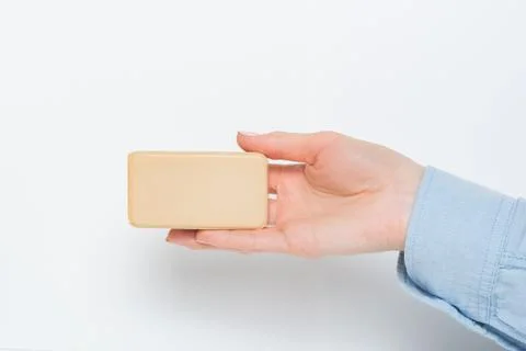 Rectangular bar of soap on a female palm. Isolated on a white background. Cop 스톡 사진