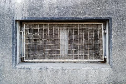 Rectangular basement or cellar window is tightened with wire metal mesh. Stock Photos