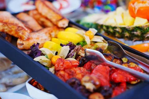 Rectangular black dish with grilled fish and vegetables. Stock Photos