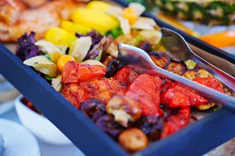 Rectangular black dish with grilled fish and vegetables. Stock Photos