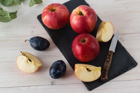 In a rectangular black dish on white wooden table are three juicy beautiful r Stock Photos