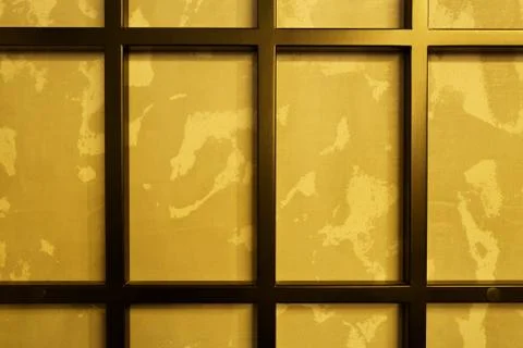 Rectangular black metal grill on the wall, with a golden background. 스톡 사진