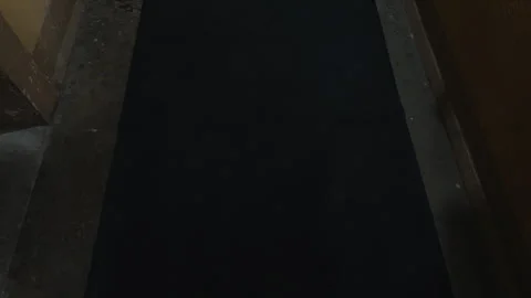 Rectangular black rug on concrete flooring in dimly lit room 스톡 동영상 275428493