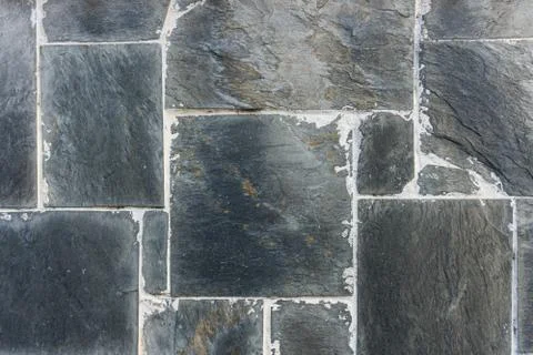 Rectangular black stones wall with dirty joins. Background texture. Stock Photos