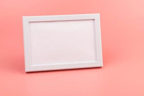 Rectangular blank white picture frame on the pink background. mockup Stock Photos