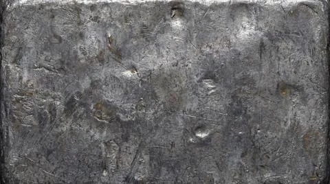 Rectangular block of distressed metallic material with rough textured surface Stockfoto's