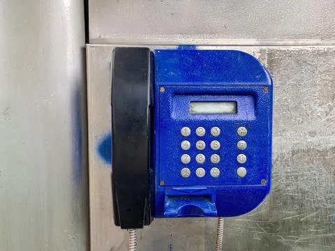 A rectangular blue telephone with white keypad and black background, mounte.. Stock Photos