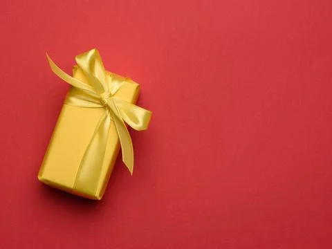 Rectangular box with a gift wrapped in yellow paper and tied with a silk yell Foto stock