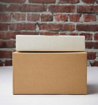 Rectangular box made of brown corrugated cardboard on a brown brick wall back Fotos Stock