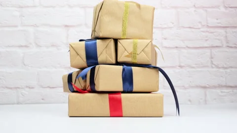 Rectangular box wrapped in brown paper and tied with a silk ribbon with a bow, g Stock Footage 143886630