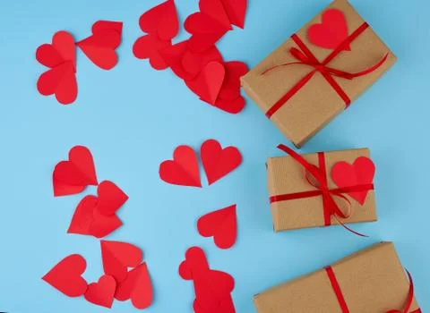 Rectangular box is wrapped in brown paper and tied with a red thin silk ribbo Stock Photos