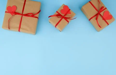 Rectangular box is wrapped in brown paper and tied with a red thin silk ribbo Foto stock