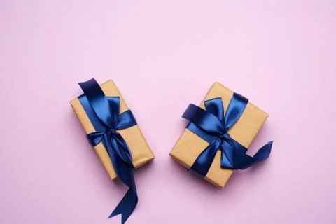 Rectangular box wrapped in brown paper and tied with a blue silk ribbon with  Stock Photos