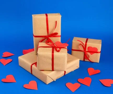 Rectangular box is wrapped in brown paper and tied with a red thin silk ri... Stockfoto's