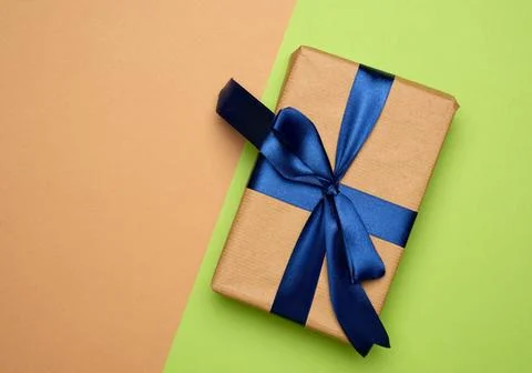 Rectangular box wrapped in brown paper and tied with a silk ribbon with a ... Stock Photos
