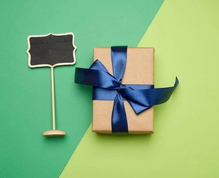 Rectangular box wrapped in brown paper and tied with a silk blue ribbon wi... Stock Photos