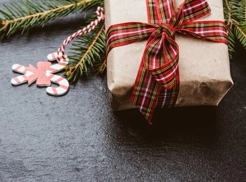 Rectangular box wrapped in brown paper and tied with a red silk ribbon wit... Stock Photos