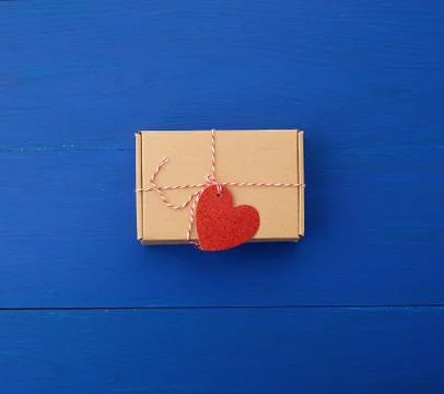 Rectangular brown box with a gift and a red paper heart tied to a rope Foto stock